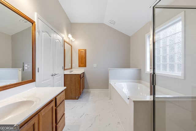 bathroom with a bathing tub, lofted ceiling, and vanity