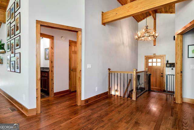 entryway featuring high vaulted ceiling, dark hardwood / wood-style flooring, beamed ceiling, and an inviting chandelier