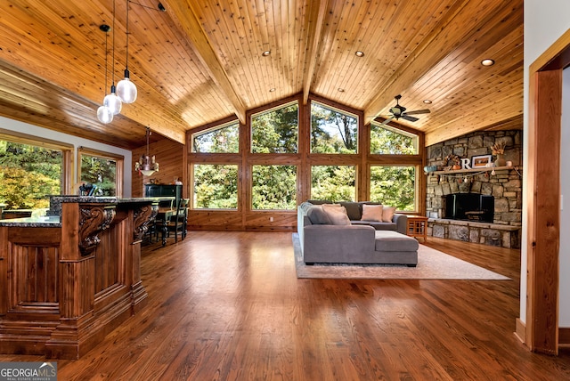 unfurnished living room featuring dark wood-type flooring, wood ceiling, ceiling fan, a fireplace, and lofted ceiling with beams