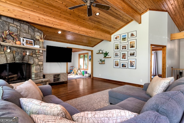 living room with vaulted ceiling with beams, a stone fireplace, wood ceiling, dark wood-type flooring, and ceiling fan