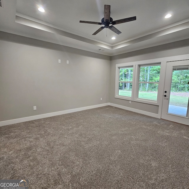 unfurnished room with ceiling fan, plenty of natural light, and a raised ceiling