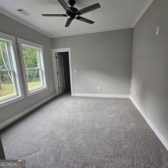 carpeted empty room featuring ceiling fan and ornamental molding