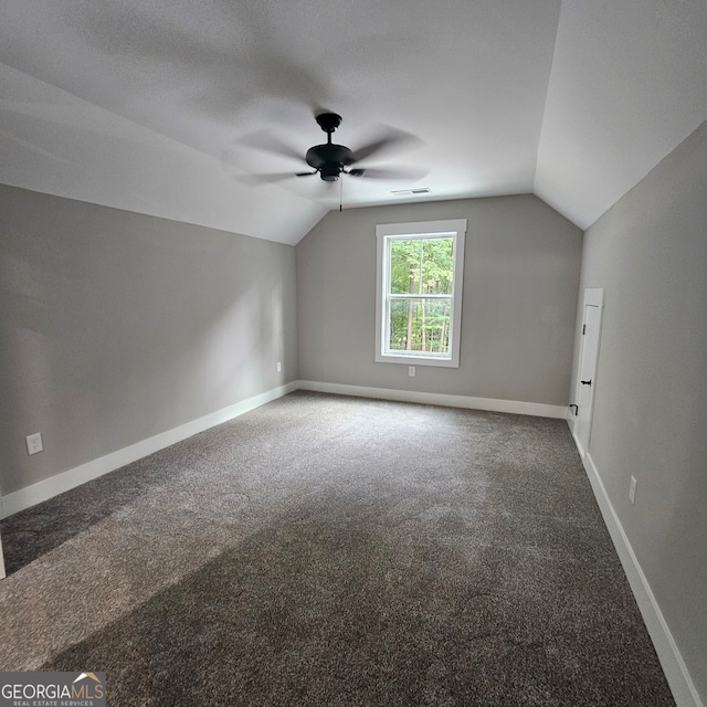 bonus room featuring lofted ceiling, carpet, a textured ceiling, and ceiling fan