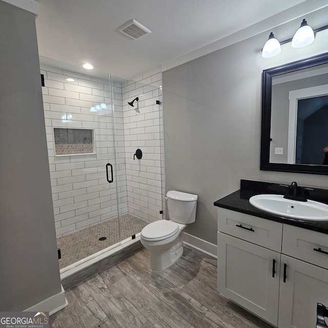 bathroom with vanity, walk in shower, hardwood / wood-style flooring, and toilet