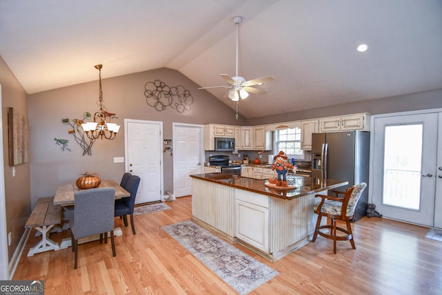 kitchen featuring stainless steel appliances, a kitchen island, a kitchen breakfast bar, light hardwood / wood-style floors, and ceiling fan with notable chandelier