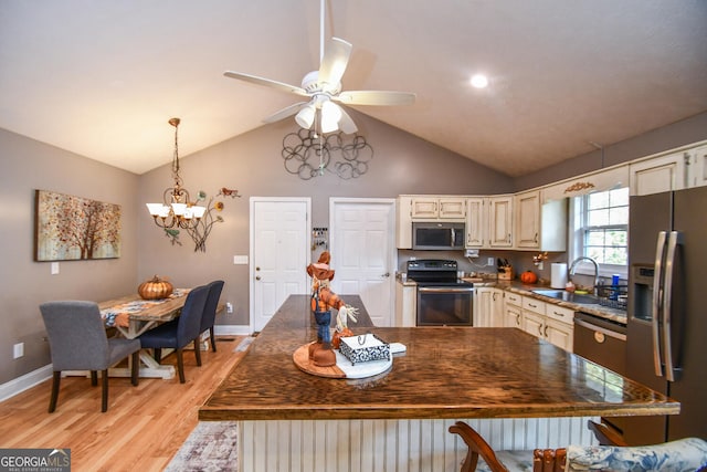 kitchen with appliances with stainless steel finishes, light hardwood / wood-style flooring, sink, lofted ceiling, and ceiling fan with notable chandelier