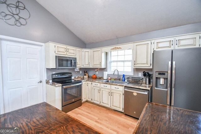 kitchen with lofted ceiling, sink, light hardwood / wood-style floors, and stainless steel appliances