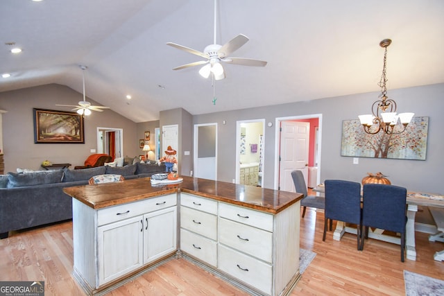 kitchen featuring butcher block counters, light hardwood / wood-style floors, white cabinets, lofted ceiling, and ceiling fan with notable chandelier