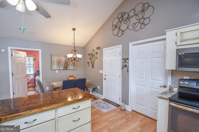 kitchen featuring ceiling fan with notable chandelier, light hardwood / wood-style floors, butcher block counters, pendant lighting, and appliances with stainless steel finishes