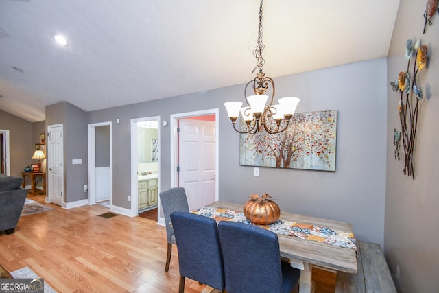 dining area with hardwood / wood-style floors and a notable chandelier