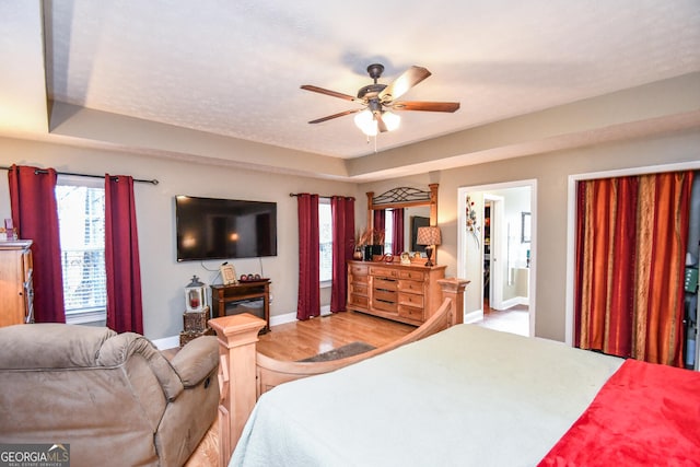 bedroom featuring a walk in closet, ceiling fan, and light hardwood / wood-style flooring