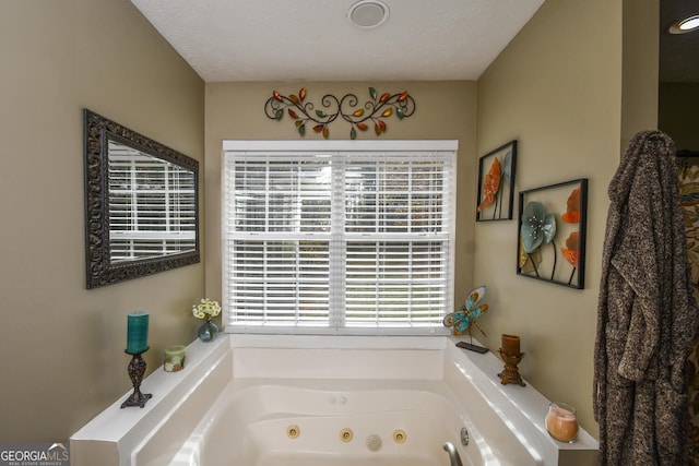 bathroom with a textured ceiling and a bathing tub