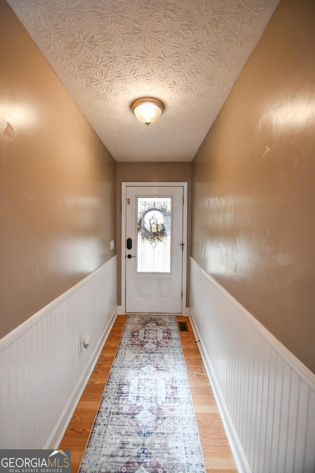 entryway featuring wood-type flooring and a textured ceiling