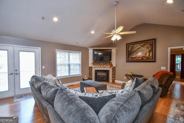 living room with ceiling fan, light hardwood / wood-style floors, french doors, and vaulted ceiling