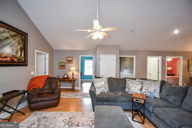 living room featuring ceiling fan, light hardwood / wood-style flooring, and lofted ceiling