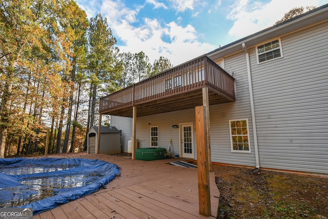 deck featuring a storage unit and a covered pool