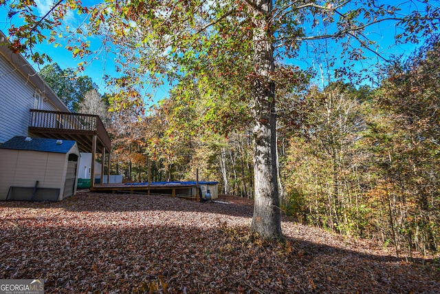 view of yard featuring a shed and a wooden deck