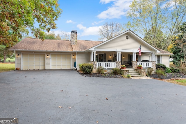 ranch-style house featuring a garage and a porch