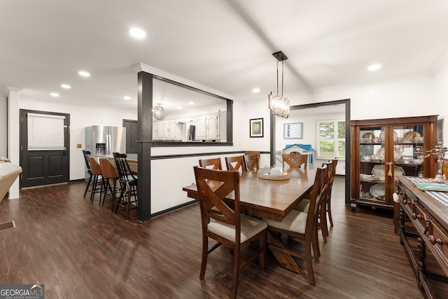 dining space with ornamental molding and dark hardwood / wood-style floors