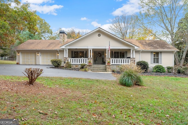 ranch-style house featuring a porch, a front lawn, and a garage