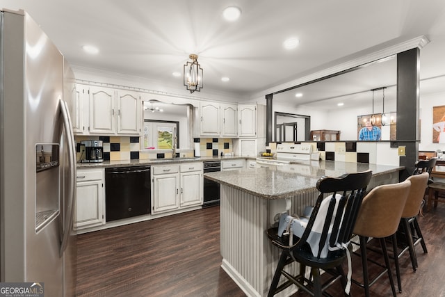 kitchen featuring dishwasher, kitchen peninsula, white cabinets, a breakfast bar area, and stainless steel fridge