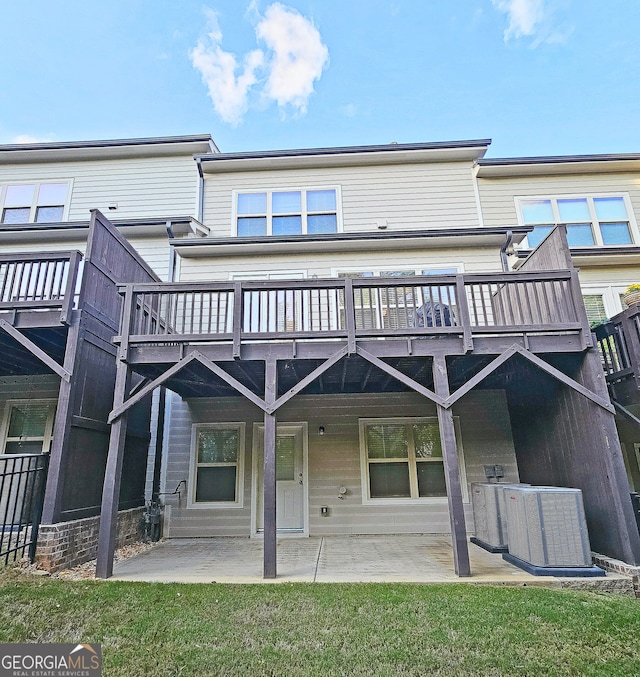 rear view of property featuring central AC, a patio area, a yard, and a deck