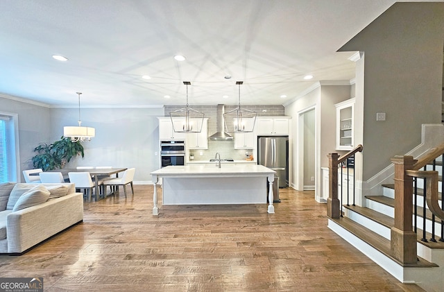 kitchen with light hardwood / wood-style flooring, decorative light fixtures, and stainless steel appliances