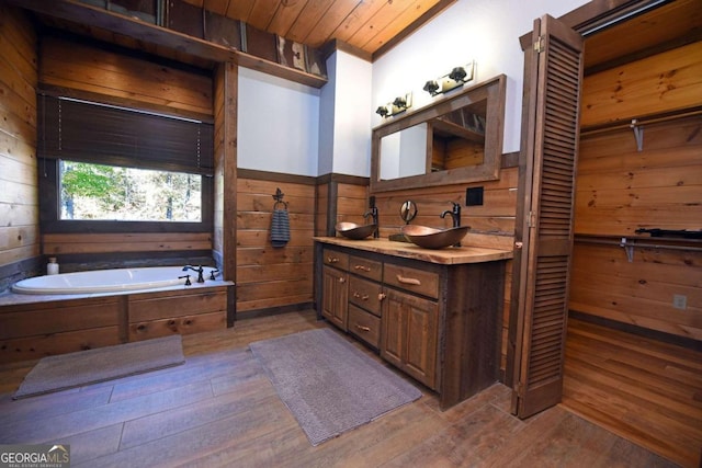 bathroom with vanity, wood walls, wooden ceiling, a washtub, and wood-type flooring