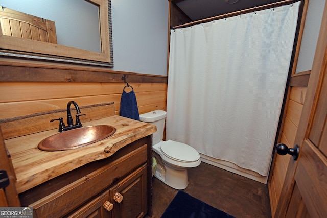 bathroom featuring vanity, toilet, curtained shower, and wood walls