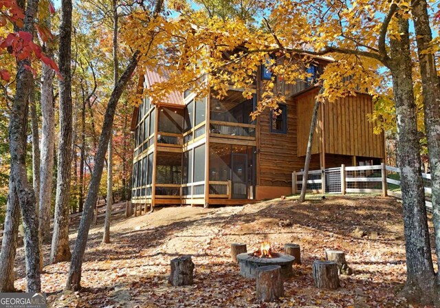 back of house with a fire pit