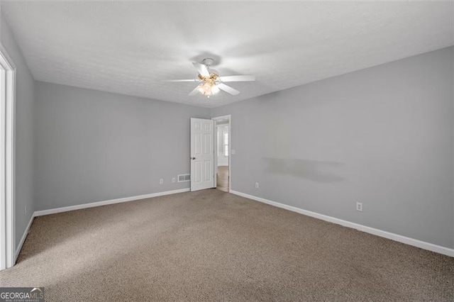 carpeted spare room featuring ceiling fan