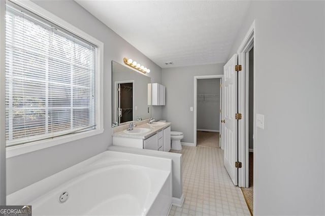 bathroom with a bath, toilet, and vanity