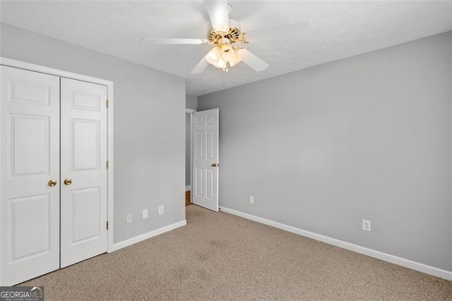 unfurnished bedroom with a closet, ceiling fan, and light carpet