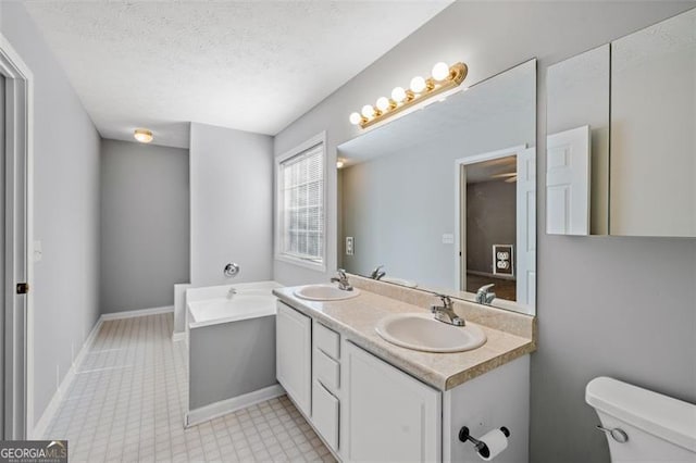 bathroom featuring toilet, a textured ceiling, and vanity