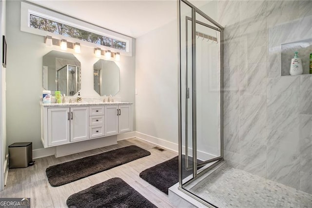 bathroom with a shower with door, vanity, and hardwood / wood-style flooring