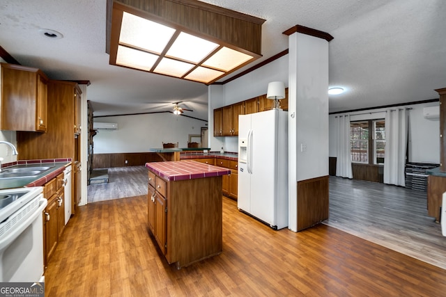 kitchen featuring sink, a center island, tile counters, ceiling fan, and white appliances