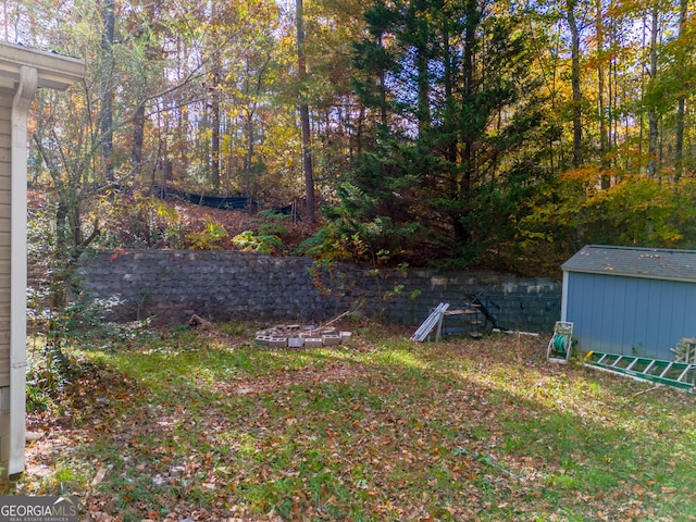 view of yard with a storage unit and a fire pit