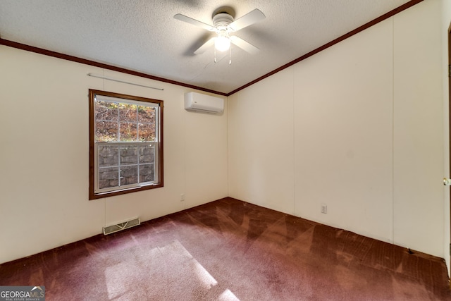 spare room featuring dark colored carpet, crown molding, a wall mounted AC, and a textured ceiling