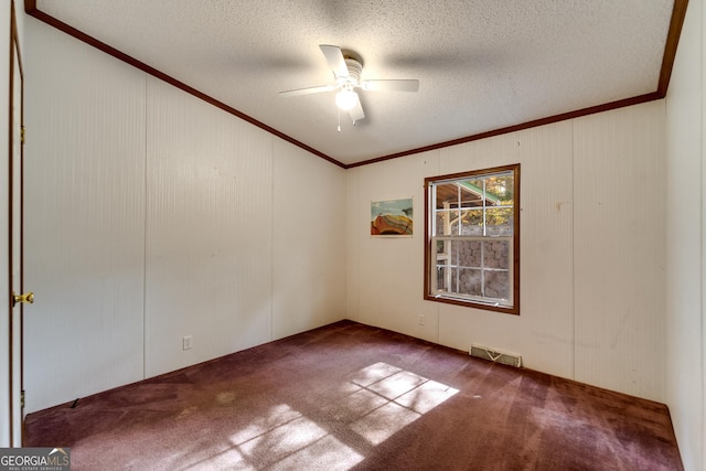 carpeted empty room featuring ceiling fan, ornamental molding, and a textured ceiling