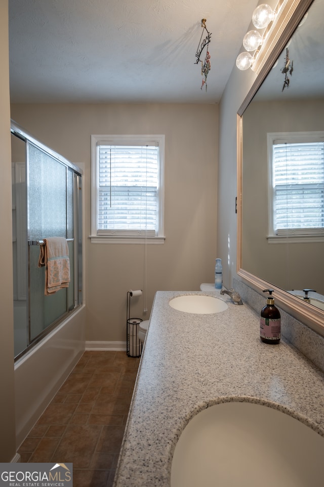 bathroom with vanity, combined bath / shower with glass door, and tile patterned flooring