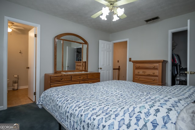 carpeted bedroom with a closet, a textured ceiling, a spacious closet, and ceiling fan