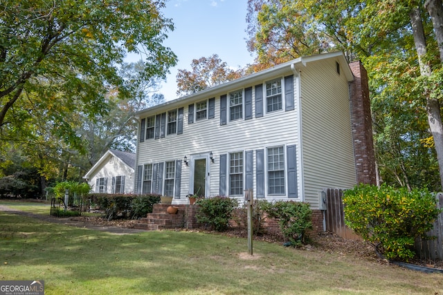 colonial-style house featuring a front yard