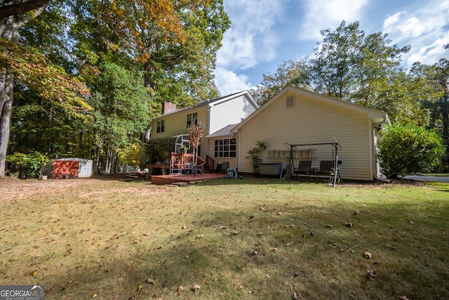 back of property with a wooden deck, a storage unit, a yard, and a patio