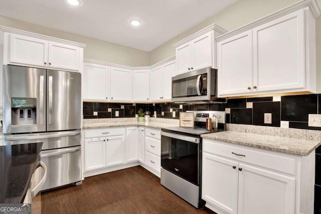 kitchen with white cabinets, stainless steel appliances, and dark wood-type flooring