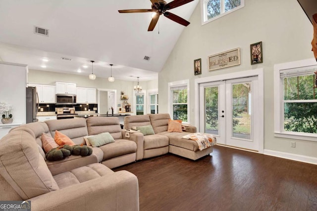 living room with a high ceiling, plenty of natural light, and dark hardwood / wood-style floors