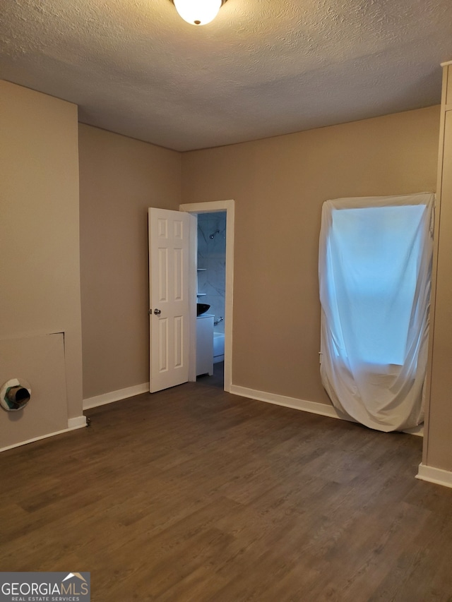 empty room featuring a textured ceiling and dark hardwood / wood-style flooring