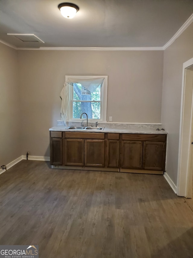 kitchen with crown molding, hardwood / wood-style flooring, and sink