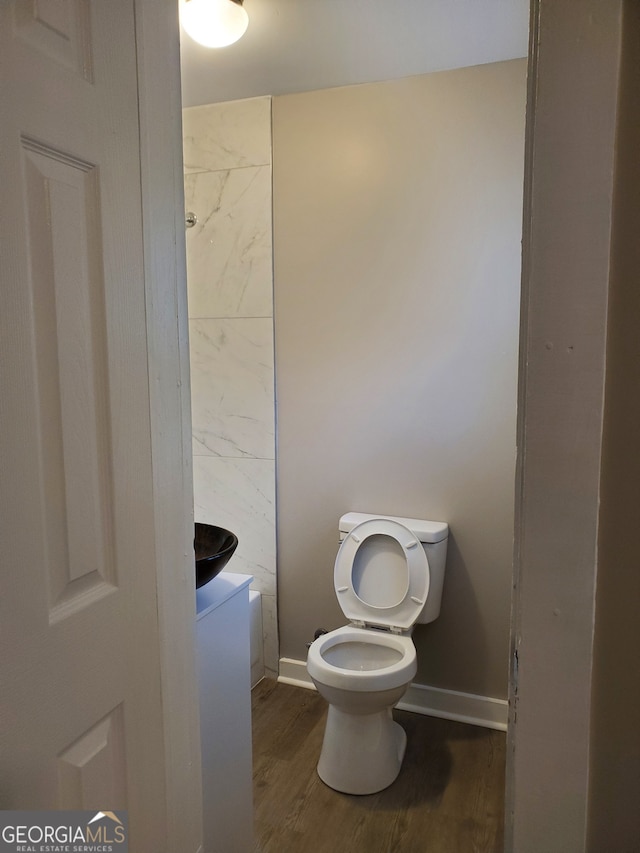 bathroom featuring wood-type flooring and toilet