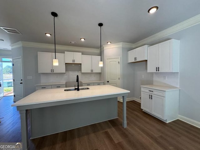 kitchen featuring white cabinets, a center island with sink, sink, and dark wood-type flooring