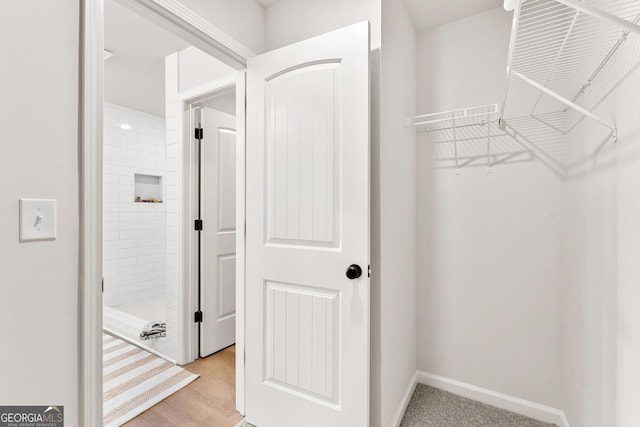 walk in closet with light hardwood / wood-style flooring